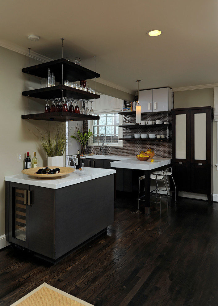 Inredning av ett modernt mellanstort kök, med en halv köksö, en undermonterad diskho, släta luckor, svarta skåp, granitbänkskiva, flerfärgad stänkskydd, stänkskydd i glaskakel, rostfria vitvaror och mellanmörkt trägolv