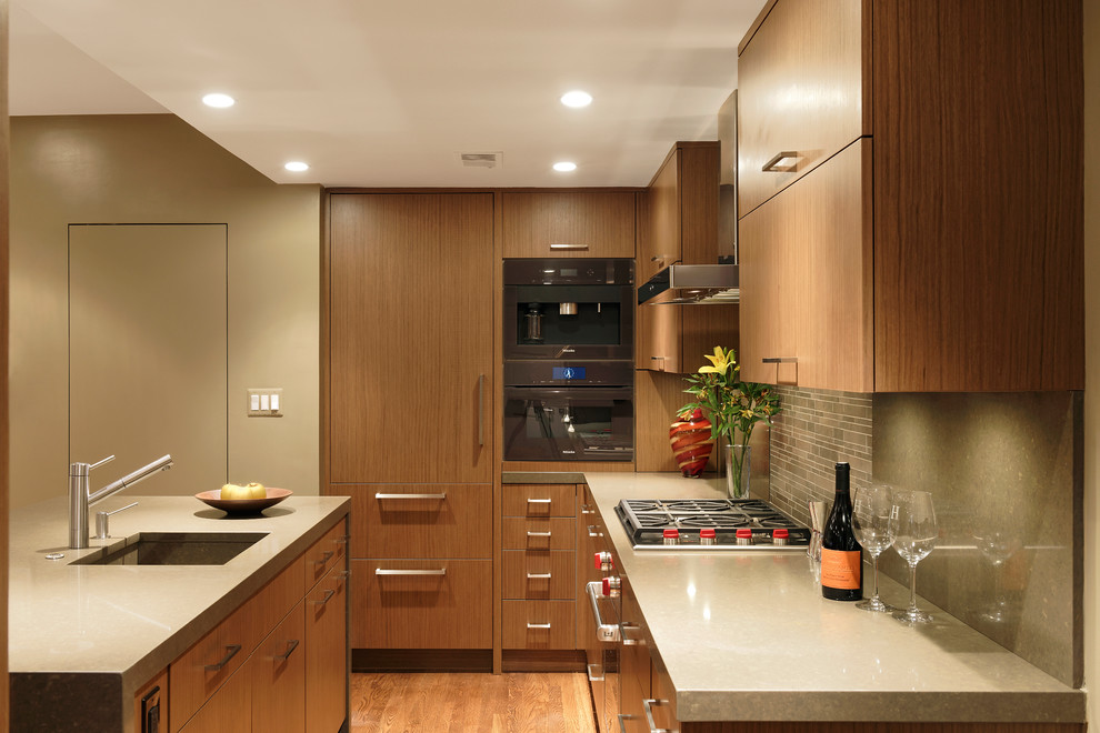 Exempel på ett mellanstort modernt kök, med en integrerad diskho, släta luckor, skåp i mellenmörkt trä, bänkskiva i kvarts, stänkskydd i stenkakel, integrerade vitvaror, en köksö, grått stänkskydd och mellanmörkt trägolv