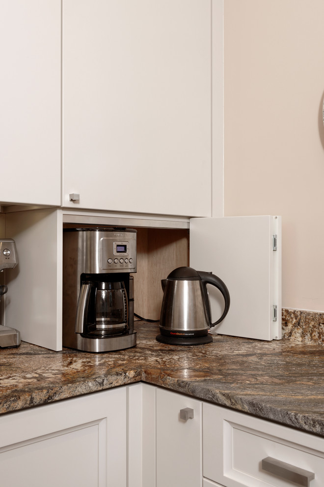 Example of a small transitional u-shaped dark wood floor eat-in kitchen design in DC Metro with an undermount sink, flat-panel cabinets, white cabinets, granite countertops, white backsplash, stone tile backsplash, stainless steel appliances and no island