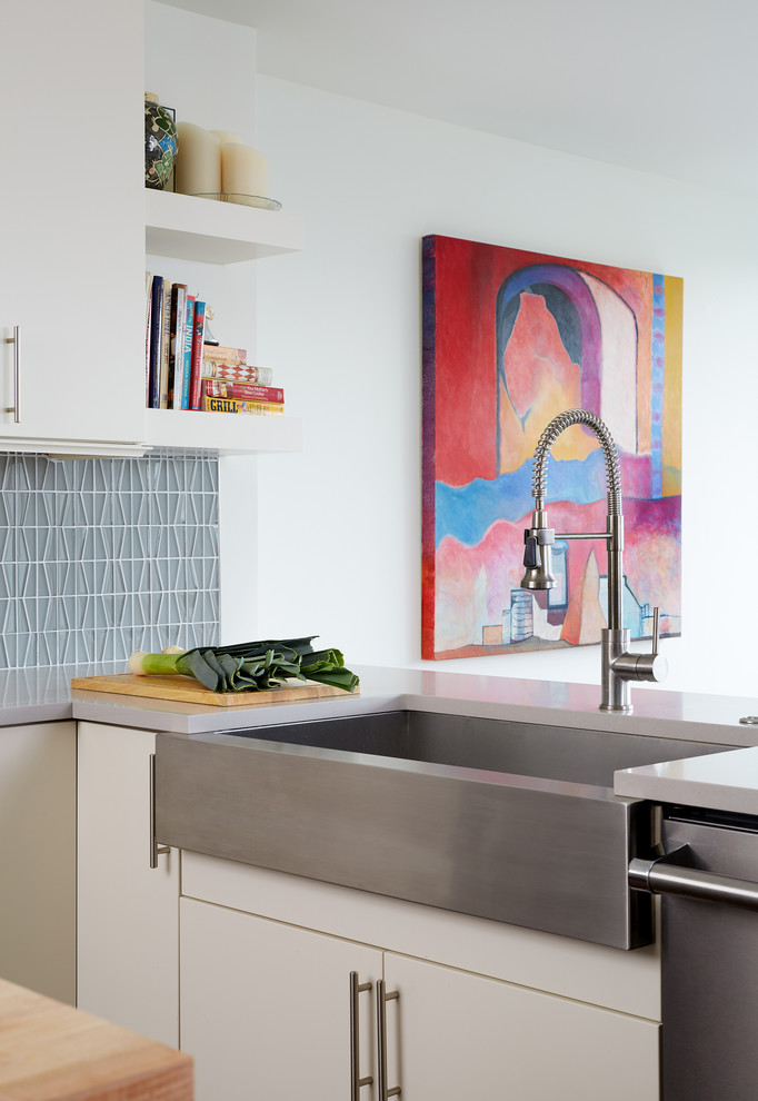 Ispirazione per una cucina minimal di medie dimensioni con ante lisce, ante bianche, paraspruzzi grigio e pavimento in legno massello medio