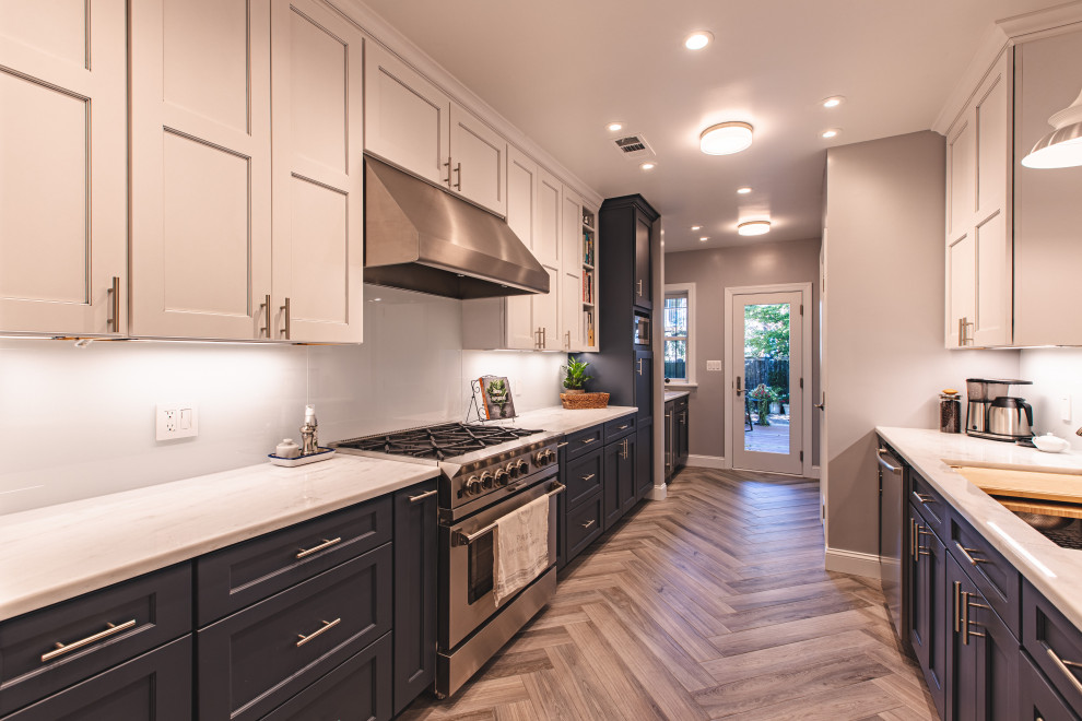 Photo of a small contemporary galley kitchen in DC Metro with a submerged sink, recessed-panel cabinets, white cabinets, marble worktops, white splashback, metro tiled splashback, stainless steel appliances, porcelain flooring, grey floors and grey worktops.