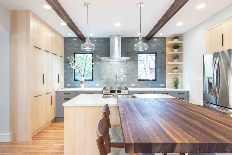 Example of a mid-sized trendy u-shaped light wood floor and beige floor eat-in kitchen design in DC Metro with a farmhouse sink, flat-panel cabinets, blue cabinets, concrete countertops, blue backsplash, subway tile backsplash, stainless steel appliances, an island and white countertops
