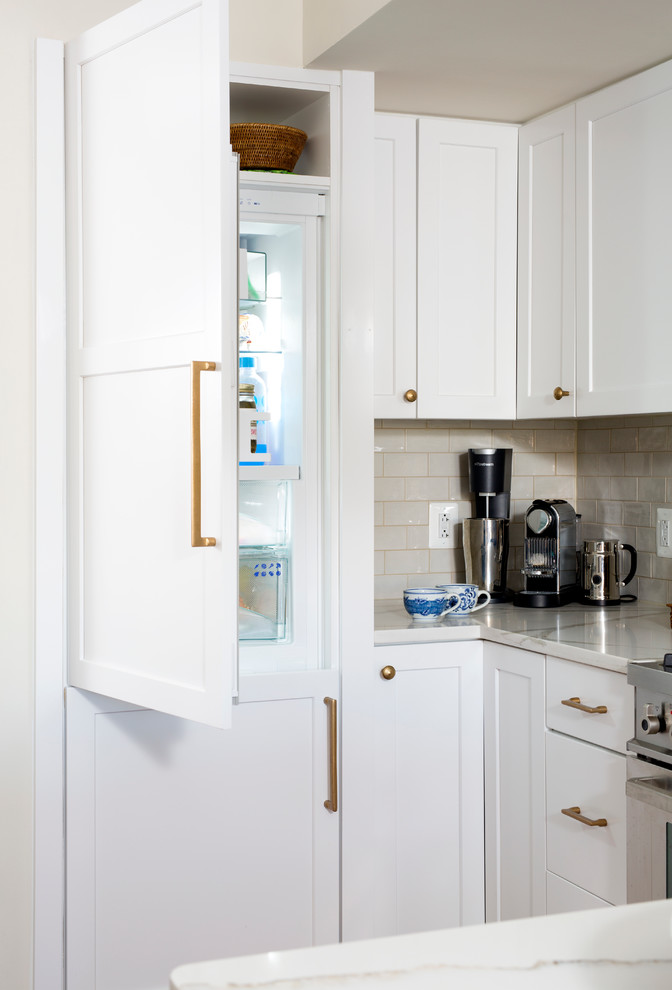 Idées déco pour une petite cuisine linéaire classique avec des portes de placard blanches, une crédence blanche, une crédence en carrelage métro, un électroménager en acier inoxydable et un sol en bois brun.