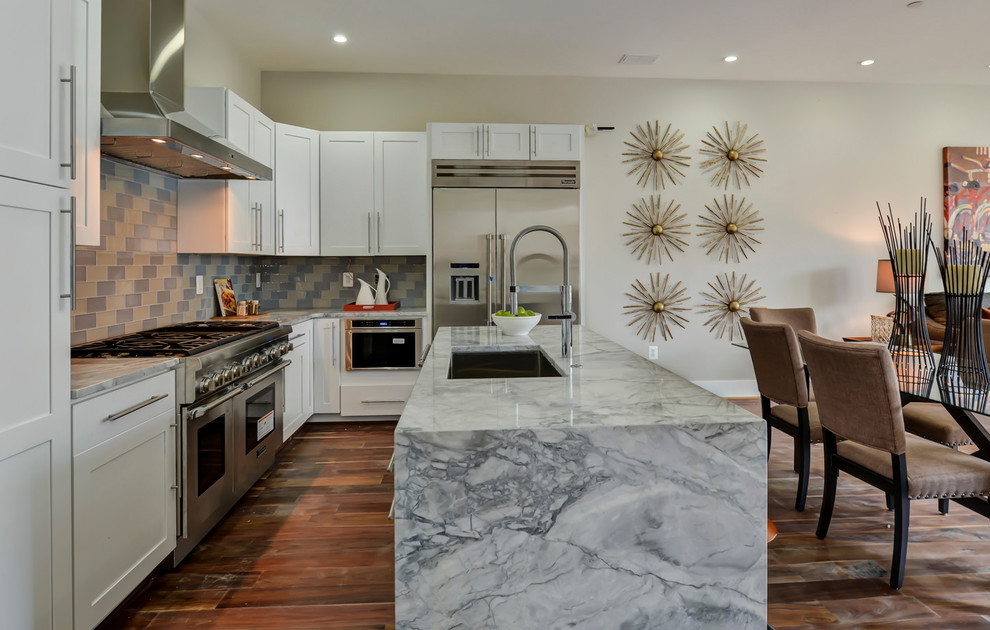 Exempel på ett modernt kök, med en nedsänkt diskho, skåp i shakerstil, vita skåp, marmorbänkskiva, flerfärgad stänkskydd, stänkskydd i tunnelbanekakel, rostfria vitvaror, mellanmörkt trägolv och en köksö