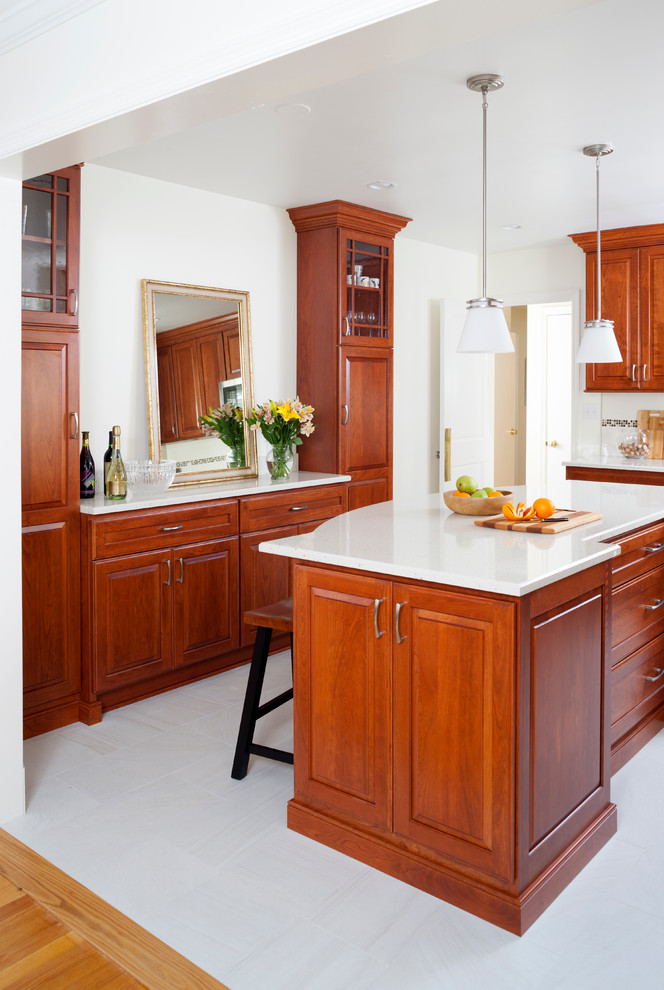 Cette photo montre une cuisine américaine chic en L et bois brun de taille moyenne avec une crédence blanche, un électroménager en acier inoxydable et îlot.