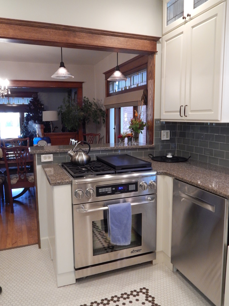 Mid-sized arts and crafts u-shaped ceramic tile eat-in kitchen photo in Denver with a farmhouse sink, raised-panel cabinets, white cabinets, quartz countertops, glass tile backsplash, stainless steel appliances, no island and green backsplash