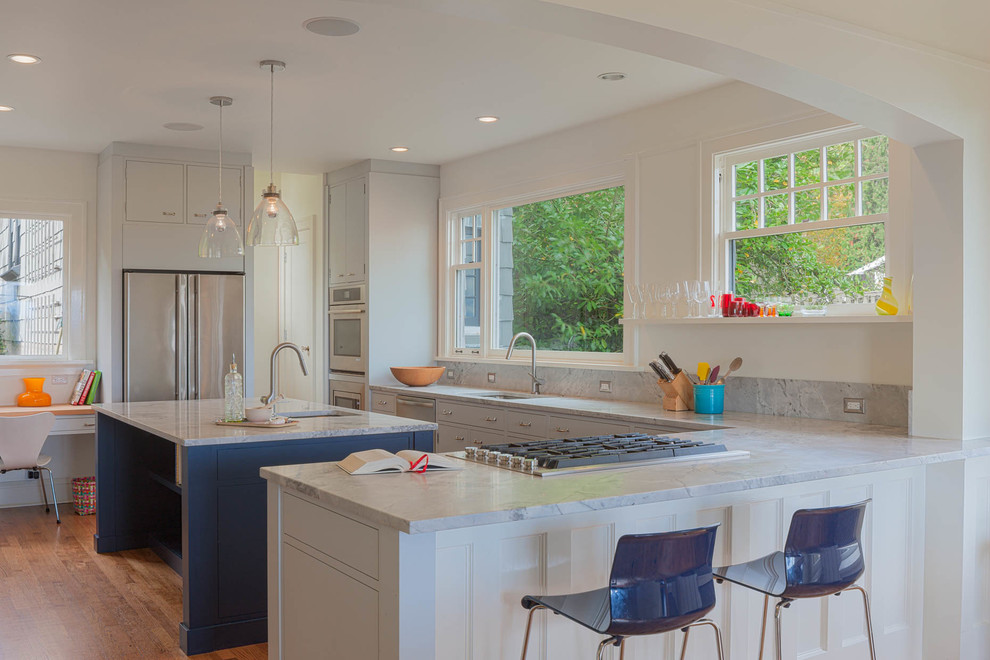Inspiration for a large modern l-shaped medium tone wood floor eat-in kitchen remodel in Seattle with an undermount sink, beaded inset cabinets, white cabinets, marble countertops, stone slab backsplash, stainless steel appliances and an island