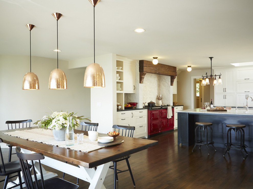 Eat-in kitchen - huge traditional u-shaped dark wood floor eat-in kitchen idea in Seattle with a farmhouse sink, recessed-panel cabinets, white cabinets, granite countertops, stone tile backsplash, colored appliances and an island