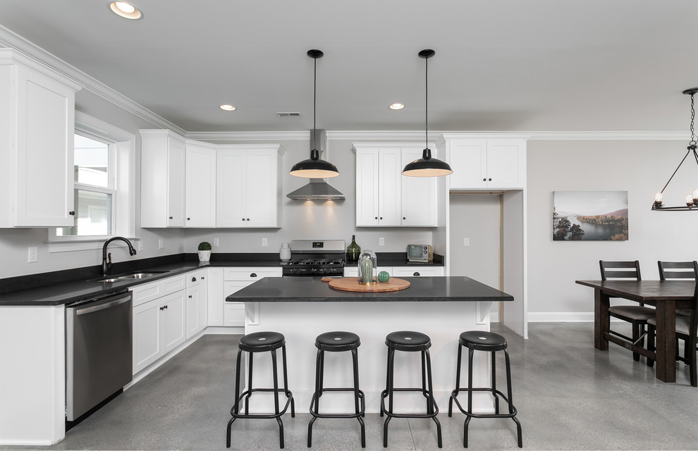 Inspiration for a medium sized classic l-shaped kitchen/diner in Other with shaker cabinets, white cabinets, engineered stone countertops, concrete flooring, an island, grey floors and black worktops.