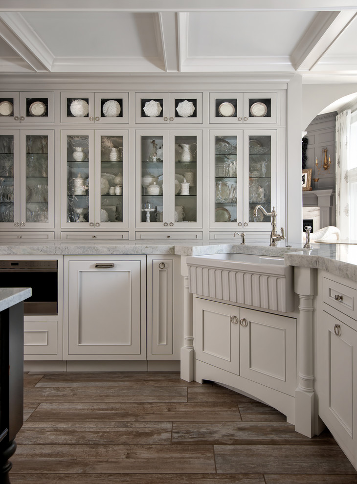 Exempel på ett stort shabby chic-inspirerat kök, med en rustik diskho, luckor med profilerade fronter, vita skåp, bänkskiva i kvartsit, blått stänkskydd, stänkskydd i glaskakel, integrerade vitvaror, klinkergolv i porslin och flera köksöar