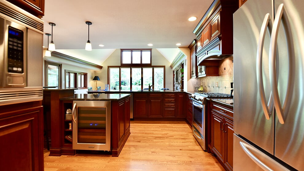 Inspiration for a huge timeless l-shaped light wood floor and beige floor eat-in kitchen remodel in Chicago with a double-bowl sink, recessed-panel cabinets, red cabinets, granite countertops, beige backsplash, stone tile backsplash, stainless steel appliances, two islands and multicolored countertops
