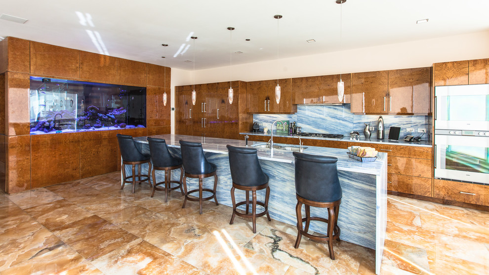 Bild på ett stort funkis l-kök, med en dubbel diskho, släta luckor, skåp i mellenmörkt trä, bänkskiva i kvarts, blått stänkskydd, stänkskydd i sten, rostfria vitvaror, marmorgolv, en köksö och brunt golv