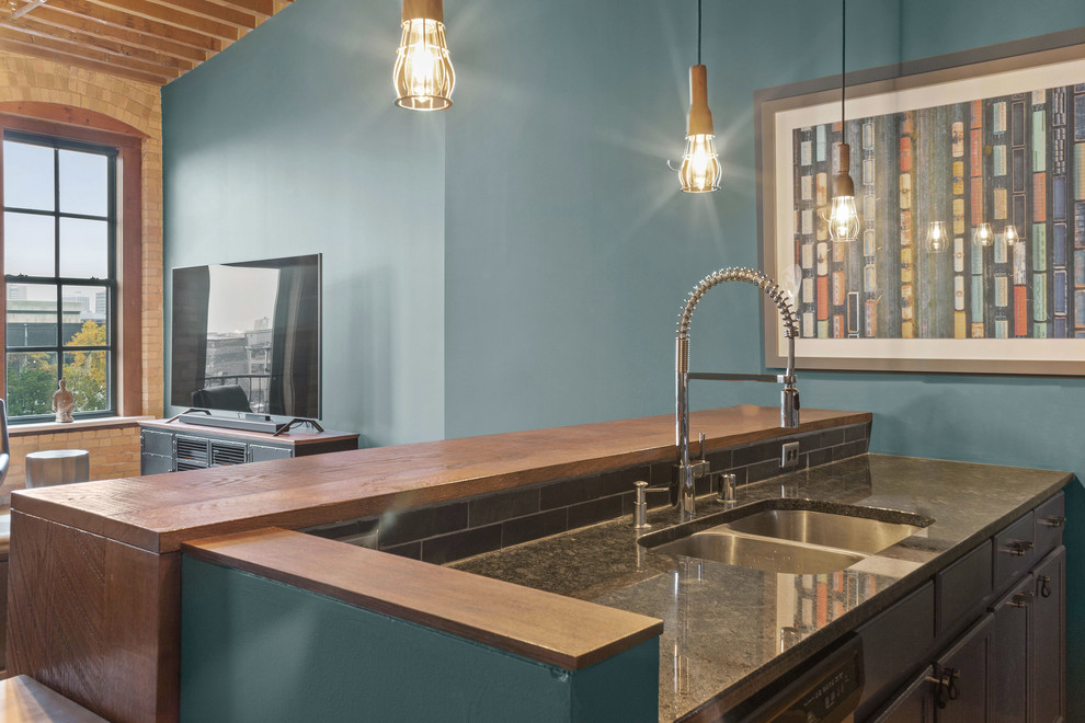 Inredning av ett modernt mellanstort grå grått kök, med en undermonterad diskho, luckor med infälld panel, blå skåp, granitbänkskiva, svart stänkskydd, stänkskydd i keramik, rostfria vitvaror, mellanmörkt trägolv, en halv köksö och brunt golv