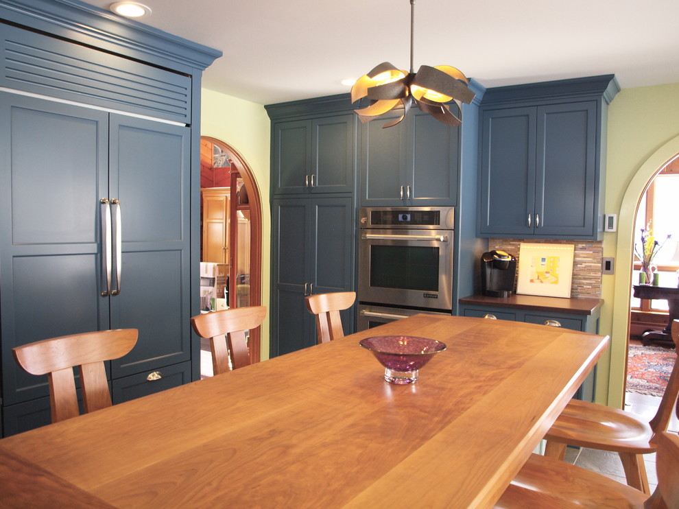 Foto på ett avskilt, stort vintage brun u-kök, med en dubbel diskho, skåp i shakerstil, blå skåp, granitbänkskiva, flerfärgad stänkskydd, stänkskydd i stickkakel, integrerade vitvaror, skiffergolv, en köksö och beiget golv