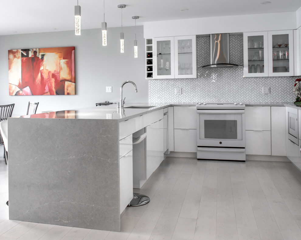 Foto di una cucina moderna di medie dimensioni con lavello sottopiano, ante lisce, ante bianche, top in quarzo composito, paraspruzzi grigio, elettrodomestici bianchi, pavimento in legno verniciato, pavimento grigio e top grigio