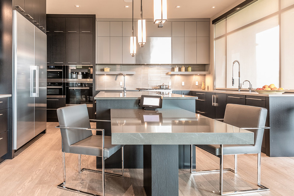 Inspiration for a large contemporary u-shaped light wood floor and gray floor eat-in kitchen remodel in Vancouver with an undermount sink, flat-panel cabinets, dark wood cabinets, quartz countertops, gray backsplash, glass tile backsplash, stainless steel appliances and an island