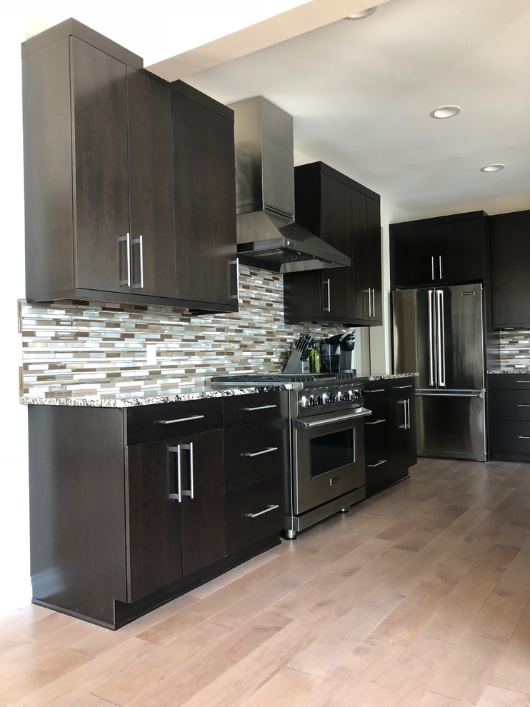 Example of a large minimalist l-shaped light wood floor and beige floor eat-in kitchen design in Detroit with an undermount sink, flat-panel cabinets, dark wood cabinets, quartz countertops, multicolored backsplash, glass tile backsplash, stainless steel appliances, an island and multicolored countertops