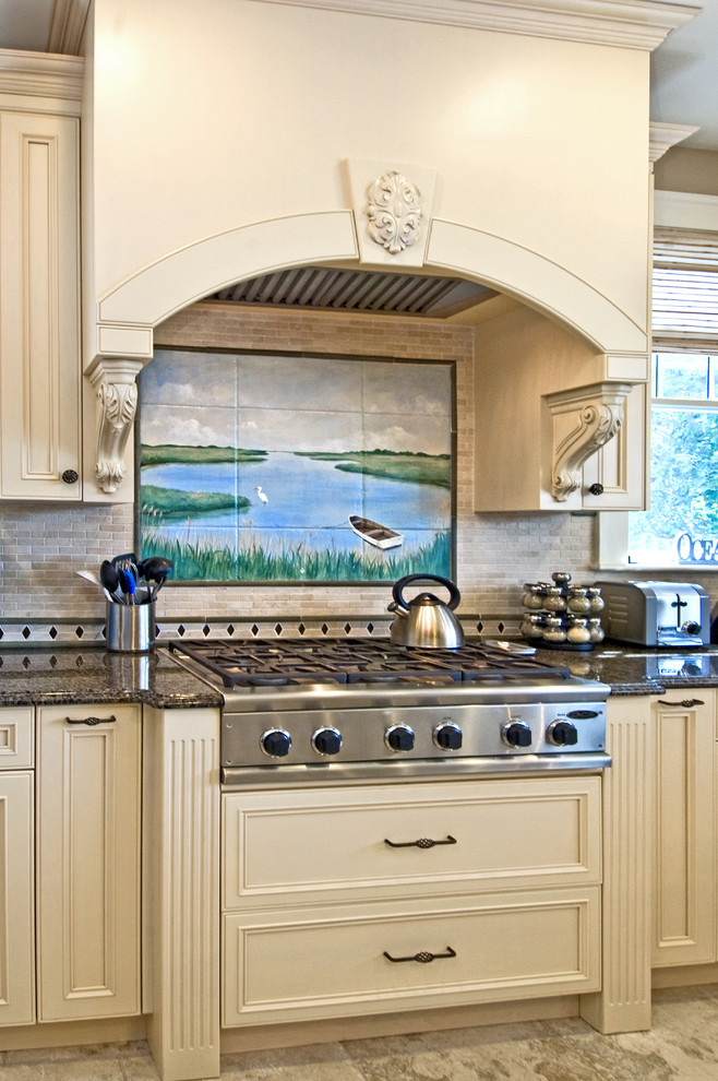 Modelo de cocina clásica con armarios con paneles empotrados, puertas de armario beige, encimera de granito y electrodomésticos de acero inoxidable