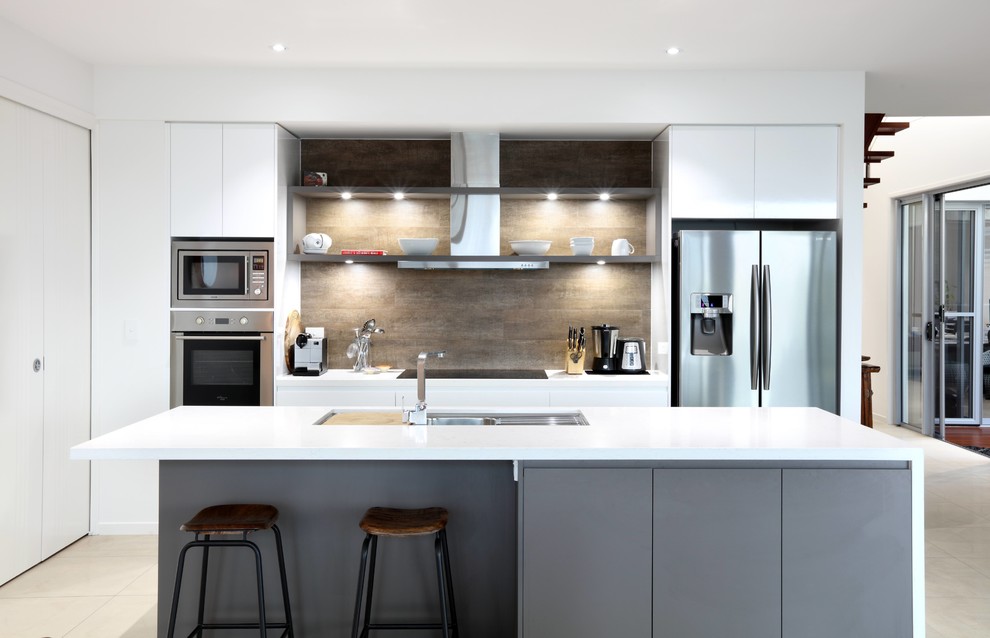 Inspiration for a medium sized contemporary galley open plan kitchen in Sunshine Coast with a submerged sink, white cabinets, engineered stone countertops, brown splashback, ceramic splashback, stainless steel appliances, ceramic flooring and an island.