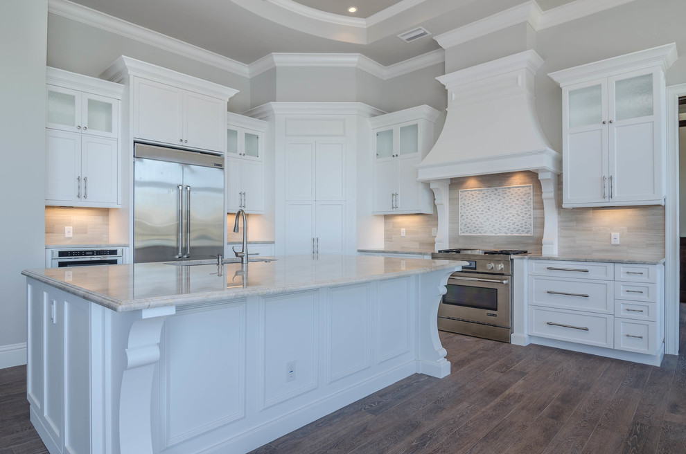Photo of an expansive traditional kitchen pantry in Miami with a submerged sink, raised-panel cabinets, white cabinets, stainless steel appliances, ceramic flooring and an island.