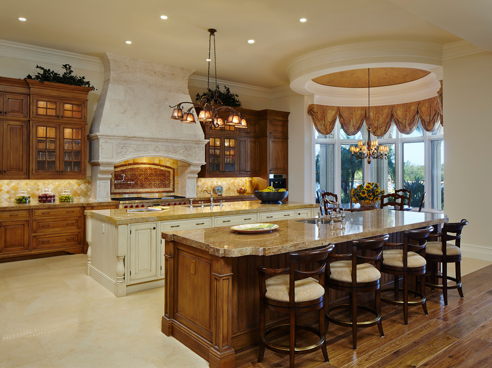 This is an example of a mediterranean l-shaped kitchen in Miami with glass-front cabinets.