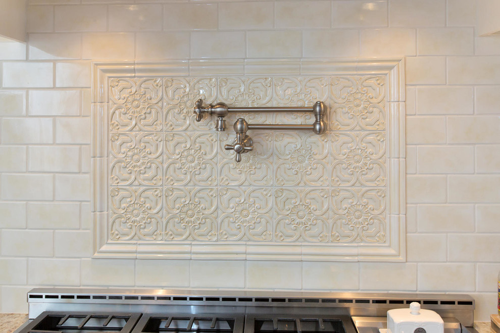 Exempel på ett stort klassiskt kök, med en undermonterad diskho, luckor med upphöjd panel, vita skåp, granitbänkskiva, vitt stänkskydd, stänkskydd i keramik, rostfria vitvaror, mellanmörkt trägolv och en köksö