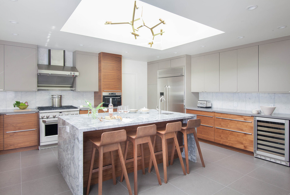 Example of a trendy porcelain tile and gray floor enclosed kitchen design in San Francisco with an undermount sink, flat-panel cabinets, medium tone wood cabinets, white backsplash, marble backsplash, stainless steel appliances, marble countertops and an island