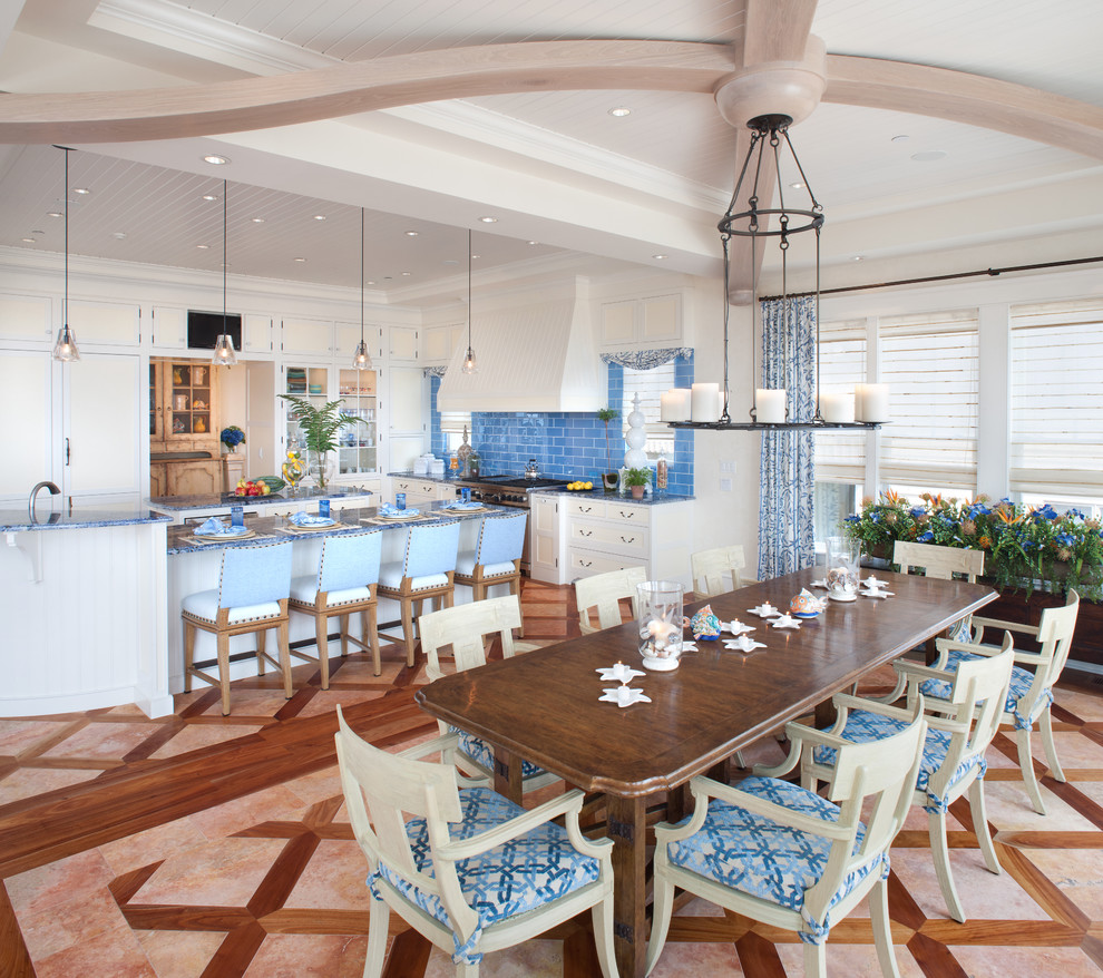 Foto på ett maritimt kök och matrum, med skåp i shakerstil, vita skåp, blått stänkskydd och integrerade vitvaror