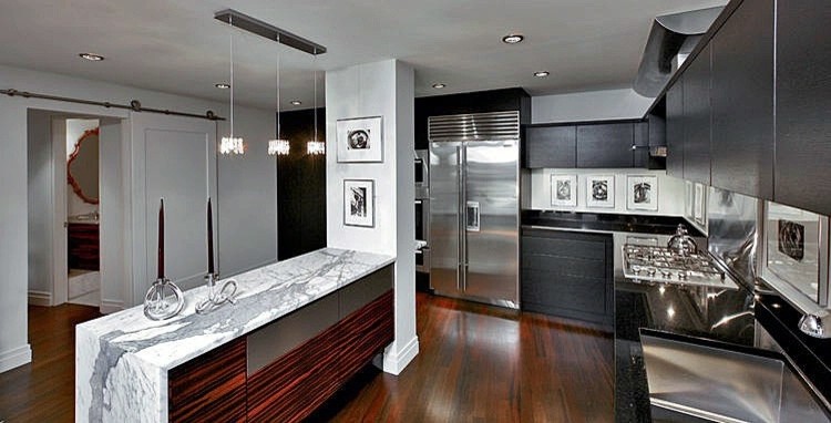 Esempio di una cucina minimal con lavello sottopiano, ante lisce, ante nere, top in marmo, paraspruzzi nero, paraspruzzi in lastra di pietra e elettrodomestici in acciaio inossidabile