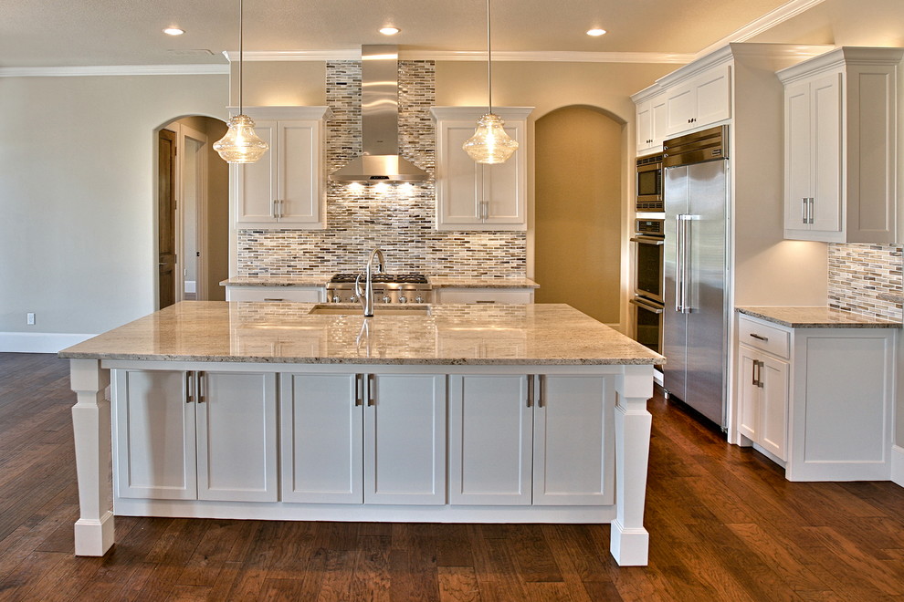 Inspiration for a large transitional u-shaped dark wood floor open concept kitchen remodel in Dallas with an undermount sink, shaker cabinets, white cabinets, granite countertops, brown backsplash, mosaic tile backsplash, stainless steel appliances and an island