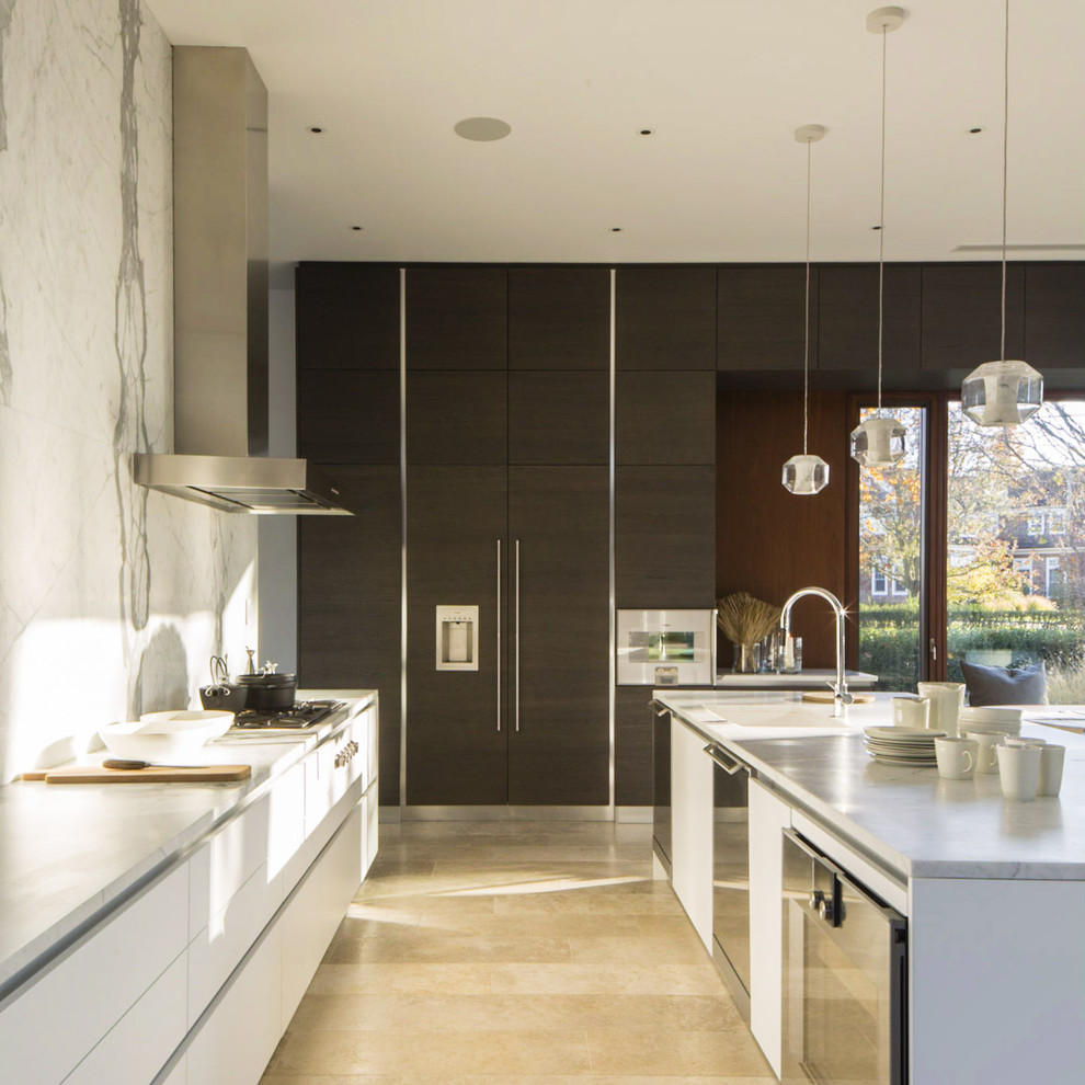 Example of a large minimalist u-shaped limestone floor and beige floor eat-in kitchen design in New York with an island, an undermount sink, flat-panel cabinets, white cabinets, marble countertops, white backsplash, stone slab backsplash and paneled appliances