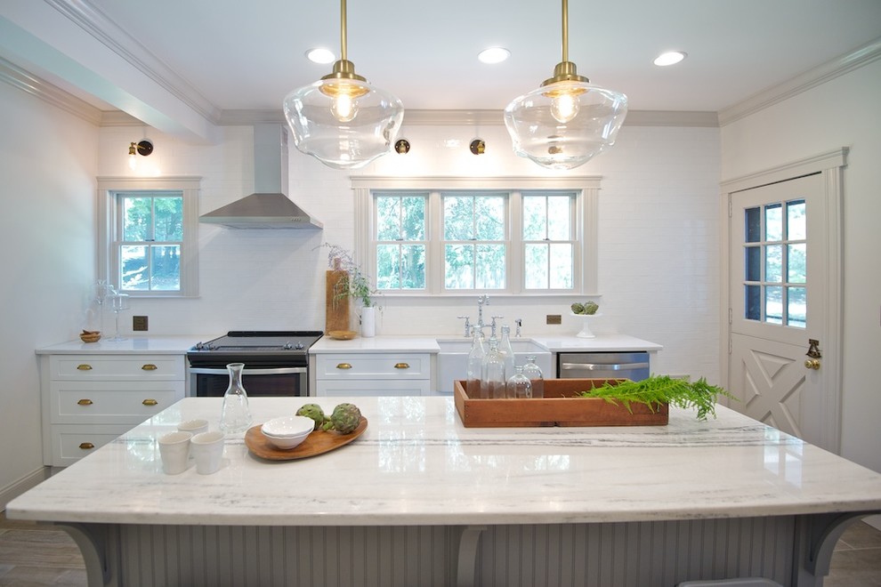 Example of a mid-sized farmhouse porcelain tile eat-in kitchen design in New York with a farmhouse sink, shaker cabinets, white cabinets, quartzite countertops, white backsplash, subway tile backsplash, stainless steel appliances and an island