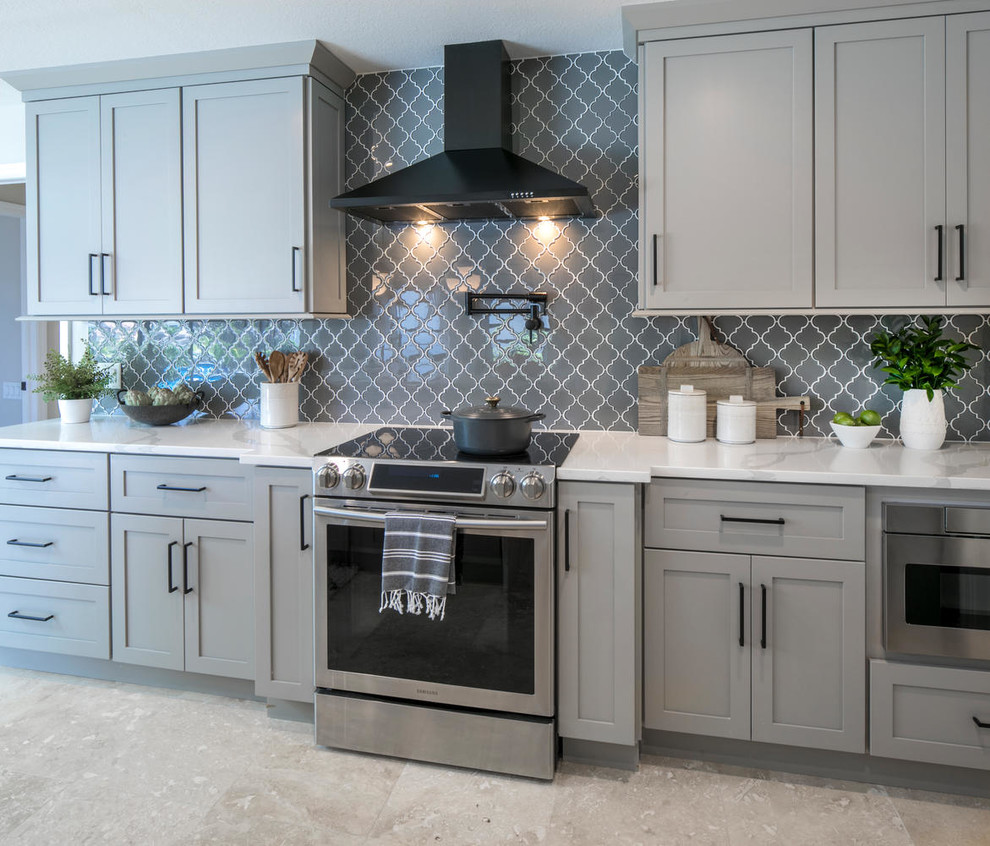 Design ideas for a large modern l-shaped kitchen in Tampa with a submerged sink, shaker cabinets, grey cabinets, engineered stone countertops, grey splashback, glass tiled splashback, stainless steel appliances, travertine flooring, an island, beige floors and white worktops.