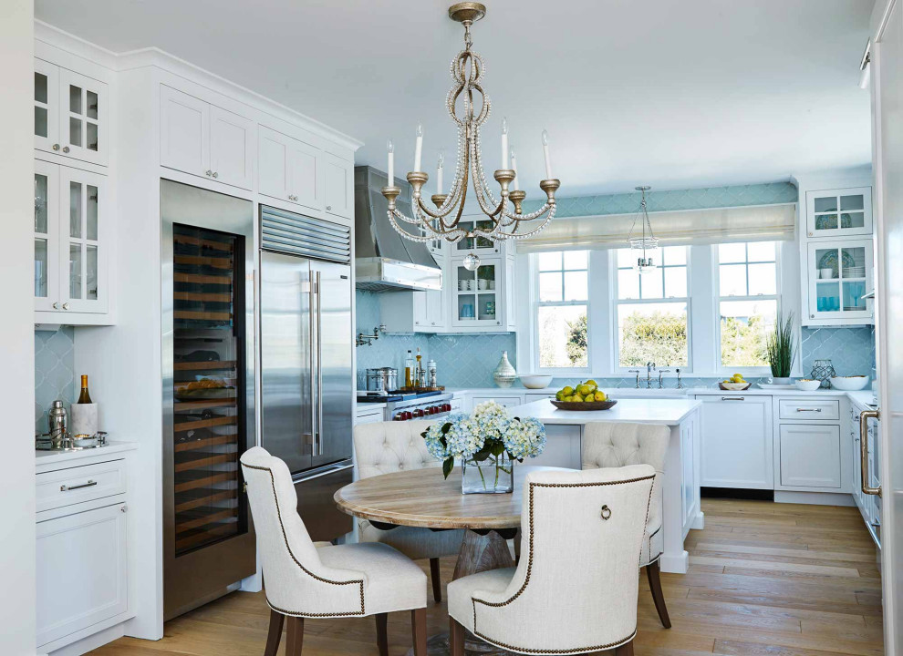 Example of a mid-sized beach style kitchen design in New York with an undermount sink, shaker cabinets, white cabinets, stainless steel appliances and an island