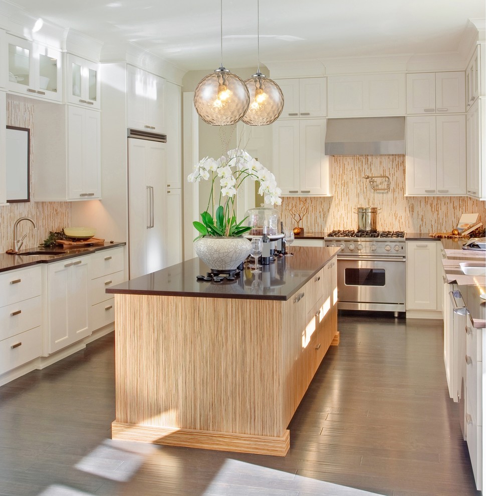 This is an example of a large contemporary u-shaped kitchen/diner in New York with a built-in sink, beaded cabinets, white cabinets, granite worktops, multi-coloured splashback, mosaic tiled splashback, stainless steel appliances, medium hardwood flooring and an island.