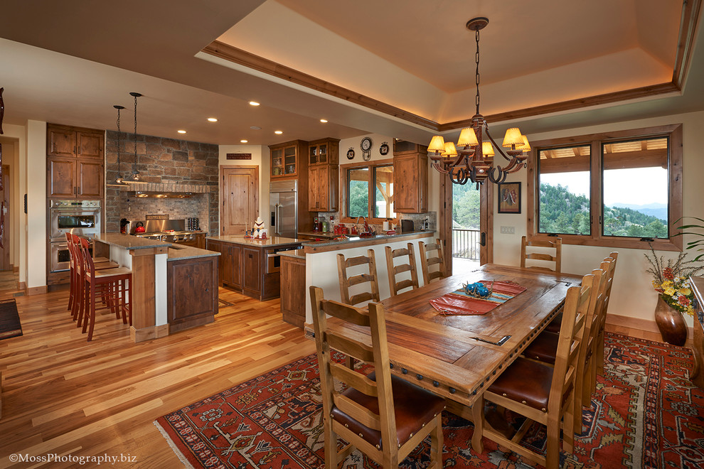 Eat-in kitchen - large traditional l-shaped light wood floor eat-in kitchen idea in Denver with an undermount sink, raised-panel cabinets, medium tone wood cabinets, quartz countertops, brown backsplash, stone tile backsplash, stainless steel appliances and an island