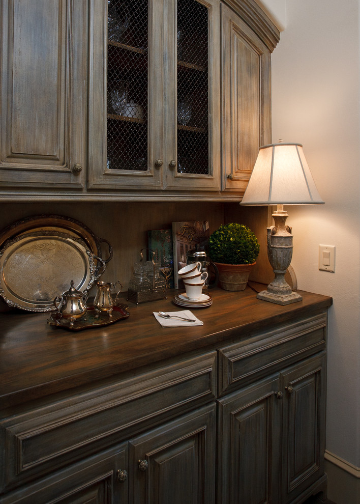 Immagine di una cucina lineare chic chiusa e di medie dimensioni con ante con bugna sagomata, ante beige, top in legno, paraspruzzi beige e pavimento marrone
