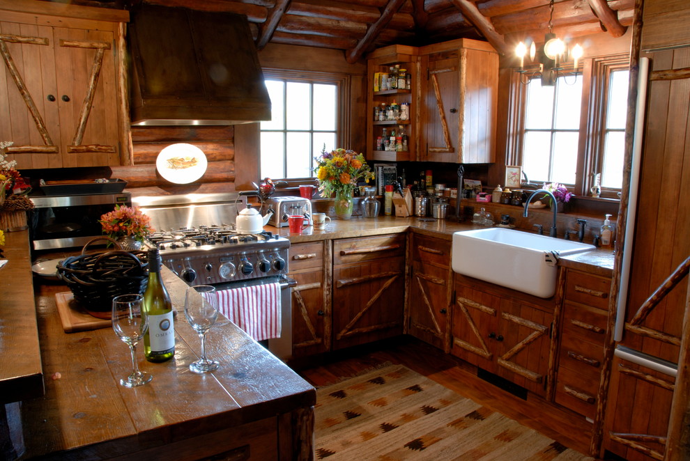 Immagine di una piccola cucina ad U rustica con lavello stile country, top in legno e penisola