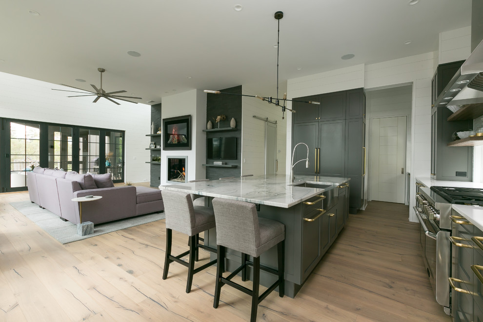 Mid-sized trendy l-shaped medium tone wood floor open concept kitchen photo in Charleston with an undermount sink, shaker cabinets, gray cabinets, marble countertops, white backsplash, ceramic backsplash, stainless steel appliances and an island