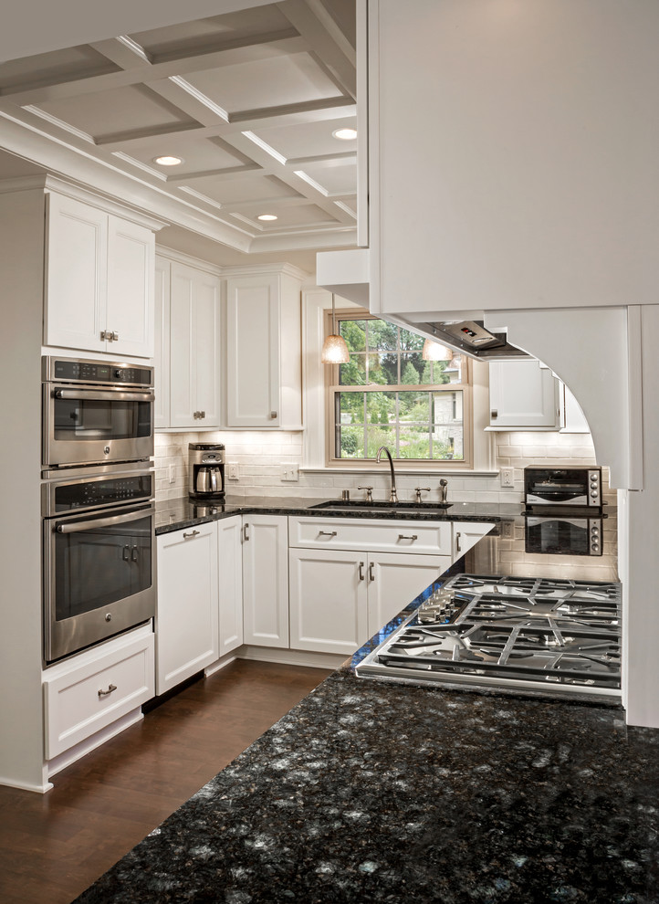 Mid-sized elegant u-shaped dark wood floor eat-in kitchen photo in Milwaukee with an undermount sink, recessed-panel cabinets, white cabinets, granite countertops, white backsplash, ceramic backsplash, stainless steel appliances and no island