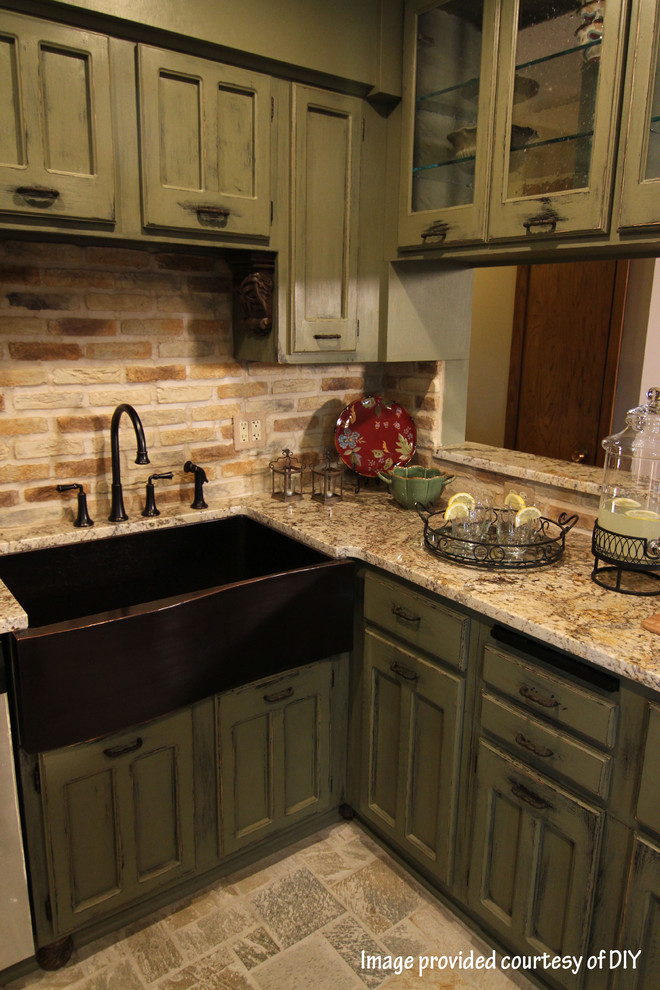 Amerikansk inredning av ett avskilt, litet l-kök, med en rustik diskho, luckor med infälld panel, gröna skåp, granitbänkskiva, flerfärgad stänkskydd, stänkskydd i tegel, integrerade vitvaror och skiffergolv