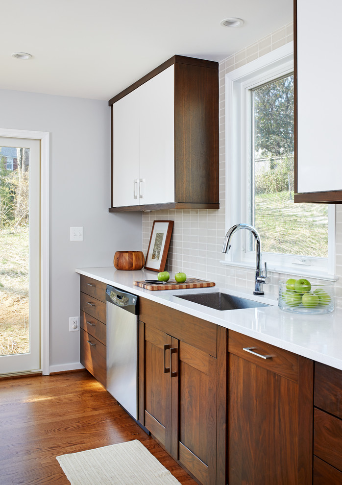 Bild på ett mellanstort funkis kök, med en undermonterad diskho, släta luckor, skåp i mellenmörkt trä, bänkskiva i kvarts, beige stänkskydd, stänkskydd i keramik, rostfria vitvaror, mellanmörkt trägolv, en köksö och brunt golv