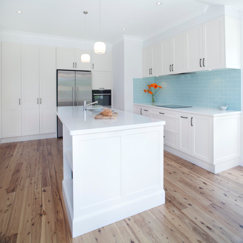 Inspiration for a large classic l-shaped kitchen/diner in Sydney with a submerged sink, shaker cabinets, white cabinets, engineered stone countertops, blue splashback, ceramic splashback, stainless steel appliances, bamboo flooring and an island.