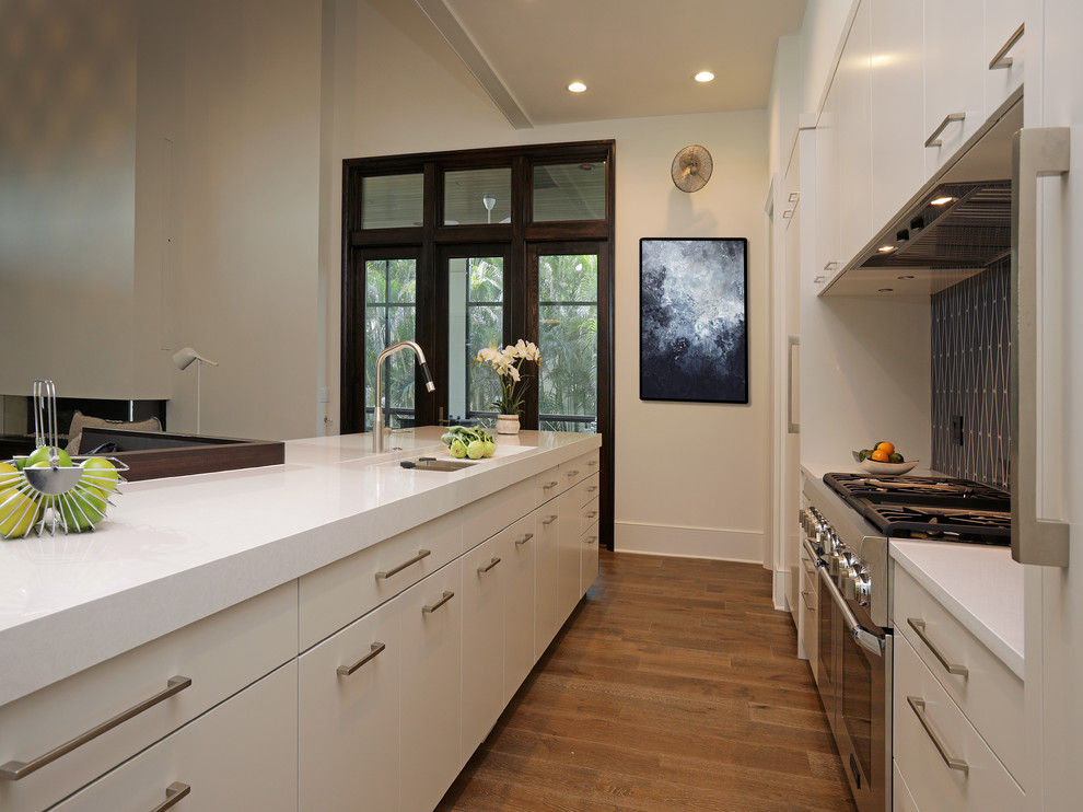Modern inredning av ett mellanstort kök, med släta luckor, vita skåp, bänkskiva i kvarts, en köksö, en undermonterad diskho, brunt stänkskydd, stänkskydd i mosaik, rostfria vitvaror och mellanmörkt trägolv