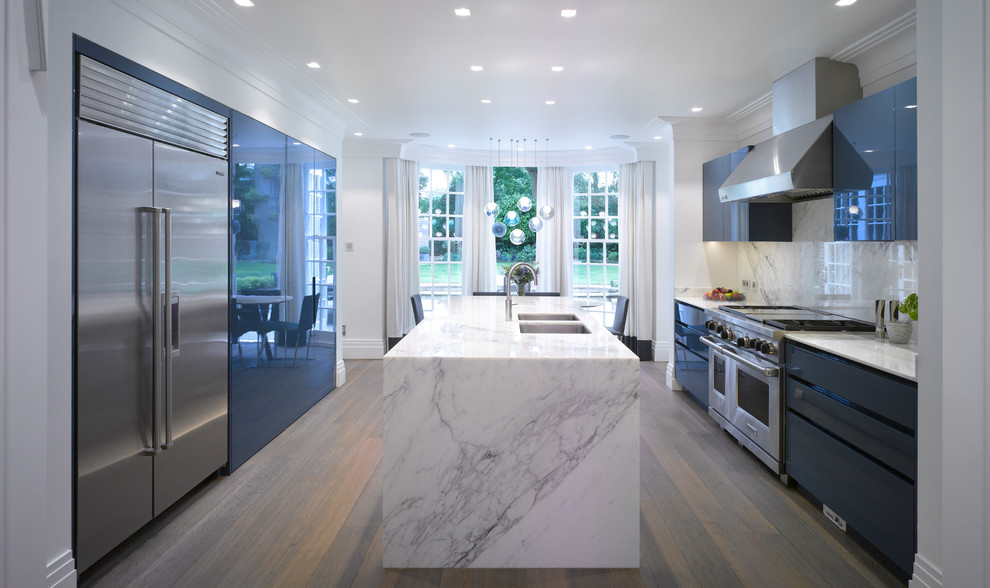 Inspiration for a large contemporary galley dark wood floor and brown floor open concept kitchen remodel in London with flat-panel cabinets, blue cabinets, marble countertops, white backsplash, marble backsplash, stainless steel appliances, an island and white countertops