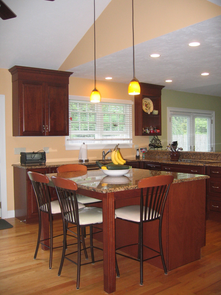 Eat-in kitchen - traditional l-shaped eat-in kitchen idea in Boston with an undermount sink, raised-panel cabinets, dark wood cabinets, granite countertops, multicolored backsplash and stone slab backsplash