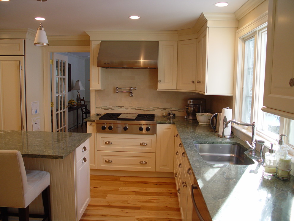 Inspiration for a timeless kitchen remodel with an undermount sink, raised-panel cabinets, white cabinets, granite countertops, stainless steel appliances and an island