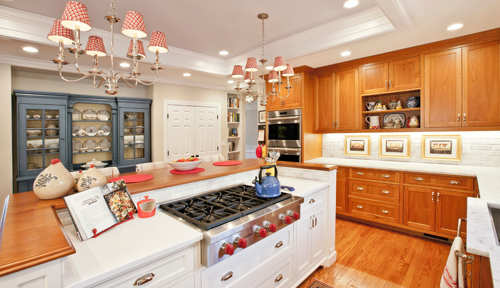 Exempel på ett stort lantligt vit vitt kök, med en undermonterad diskho, luckor med infälld panel, orange skåp, marmorbänkskiva, vitt stänkskydd, stänkskydd i tegel, rostfria vitvaror, mellanmörkt trägolv, en köksö och brunt golv