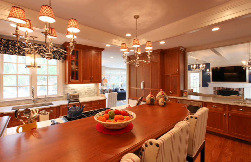Idéer för ett stort lantligt vit kök, med en undermonterad diskho, luckor med infälld panel, orange skåp, marmorbänkskiva, vitt stänkskydd, stänkskydd i tegel, rostfria vitvaror, mellanmörkt trägolv, en köksö och brunt golv