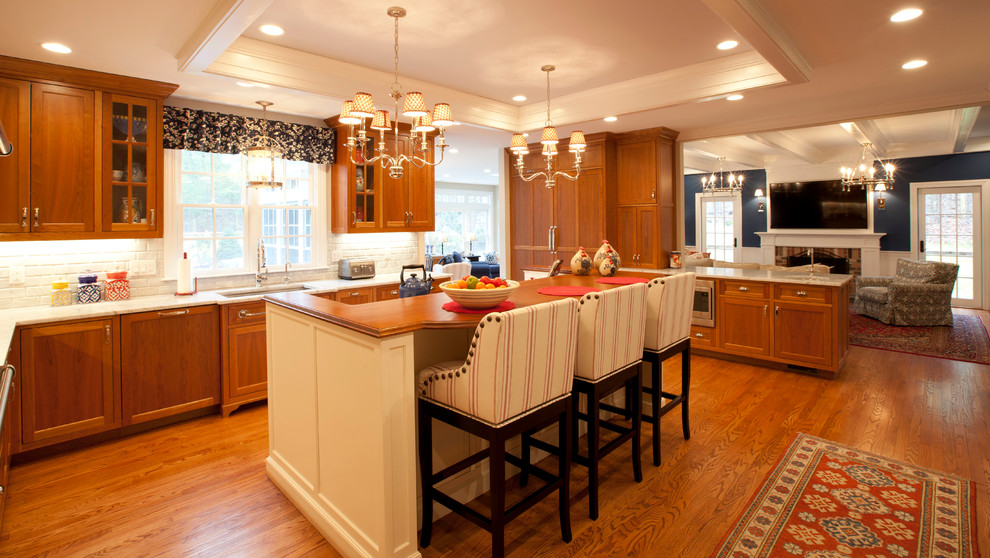Idéer för stora lantliga vitt kök, med en undermonterad diskho, luckor med infälld panel, orange skåp, marmorbänkskiva, vitt stänkskydd, stänkskydd i tegel, rostfria vitvaror, mellanmörkt trägolv, en köksö och brunt golv
